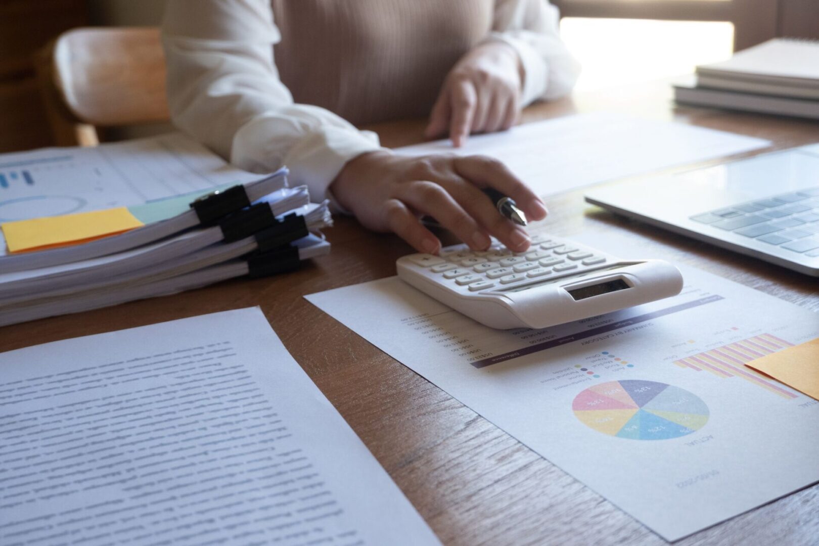 Person using calculator and financial documents.